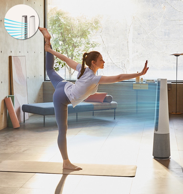 A woman is exercising in the room and the product is blowing the air as direct mode in front of the woman.