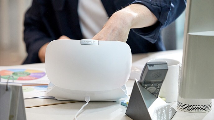 The power connector is plugged into the back of the PuriCare wearable case.