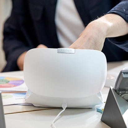 The power connector is plugged into the back of the PuriCare wearable case.