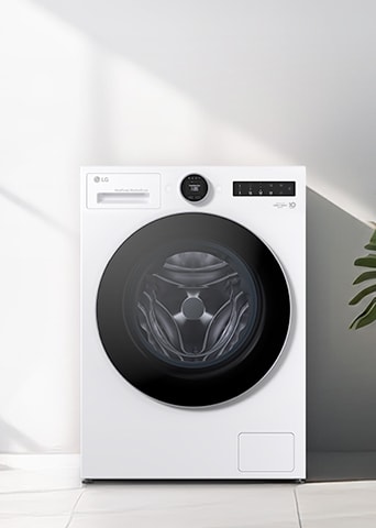 LG white front load washer dryer is placed under sunlight from the left, with a few plants visible on the right.