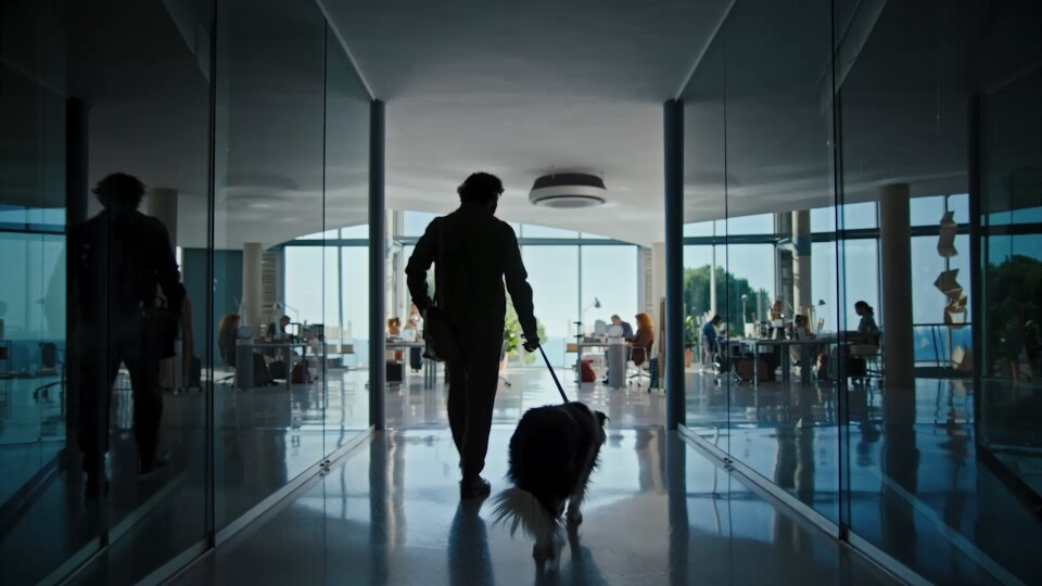 A man holding a dog leash heads to an office. Another man wrinkles his nose and touches it, seemingly reacting to a bad smell.Behind the dog, the LG Puricare air purifier comes into view. The man gestures in dissatisfaction, and a red light turns on in the air purifier.