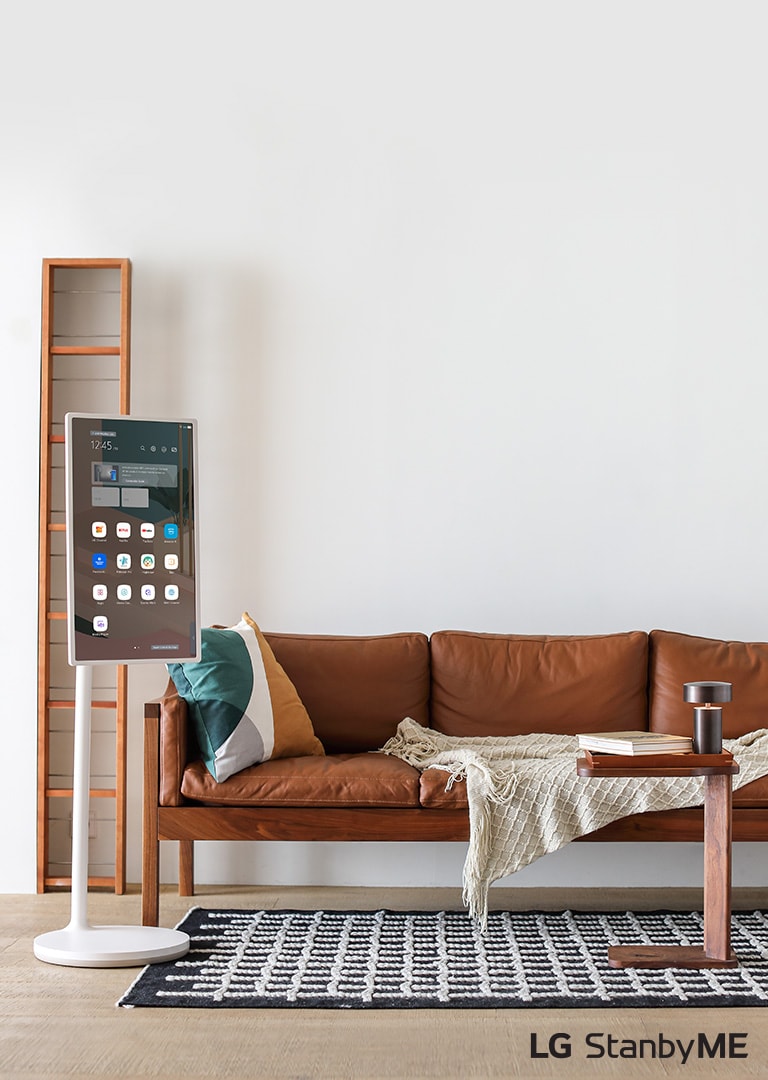 EASEL in Line View leaning against a wall with decorative molding. It sits next to a painting on the wall and behind an intricately designed rug. 10 Year World's No.1 OLED TV emblem.