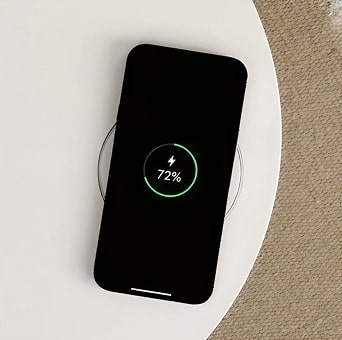 Image of LG Aerospeaker top surface used for wireless charging, powering a smartphone at 72 percent.