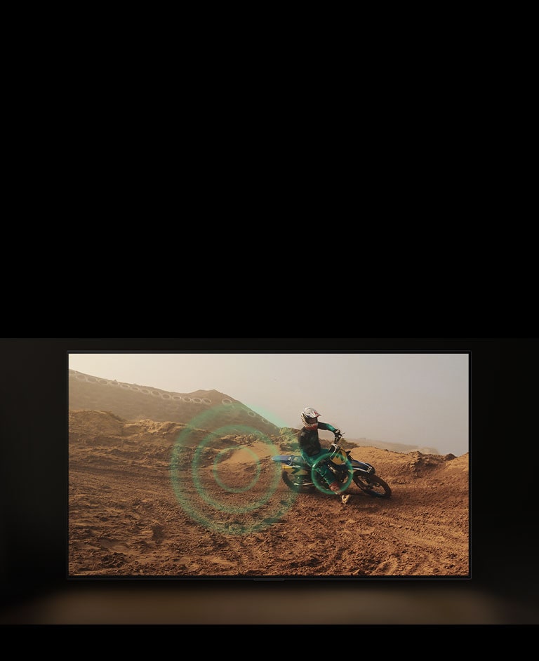 A video of a person dirt biking on red, dusty land. As they take a corner, green sound bubbles appear from the wheel. 