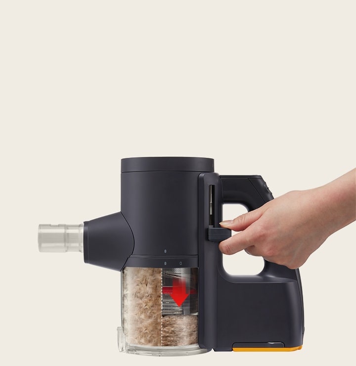 Hand operating the kompressor to release lever on the LG a9k-legend3 vacuum to empty collected debris efficiently.	