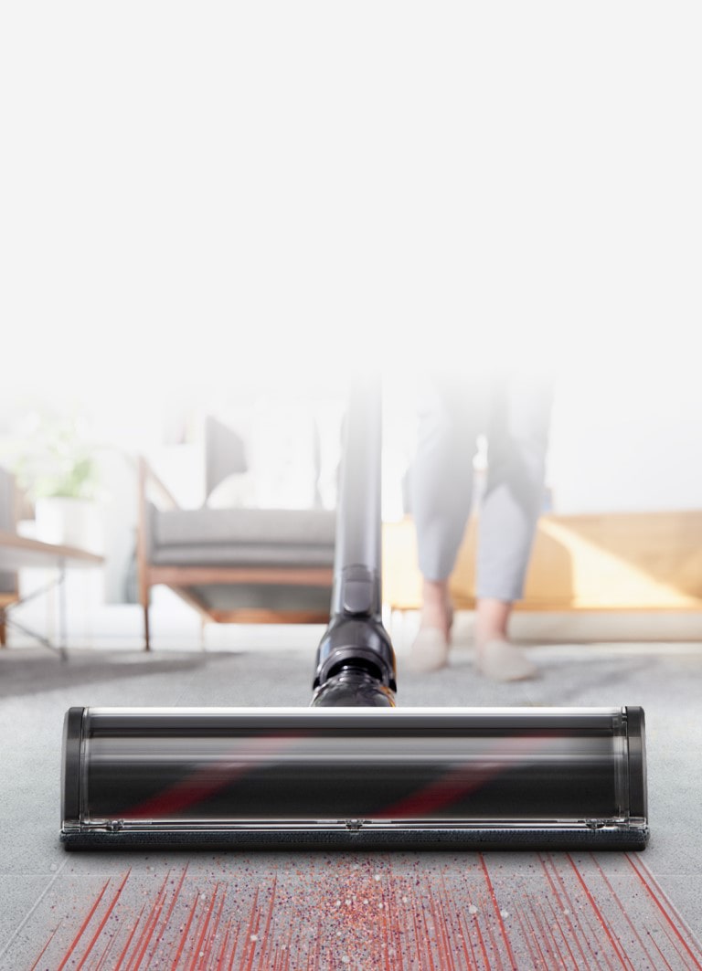 The head of the vacuum cleaner is quickly sucking up dust on the carpet showing strong suction capability.