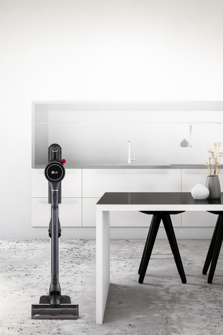 The CordZero A9 Kompressor Vacuum is in the charging stand in an office next to a desk.