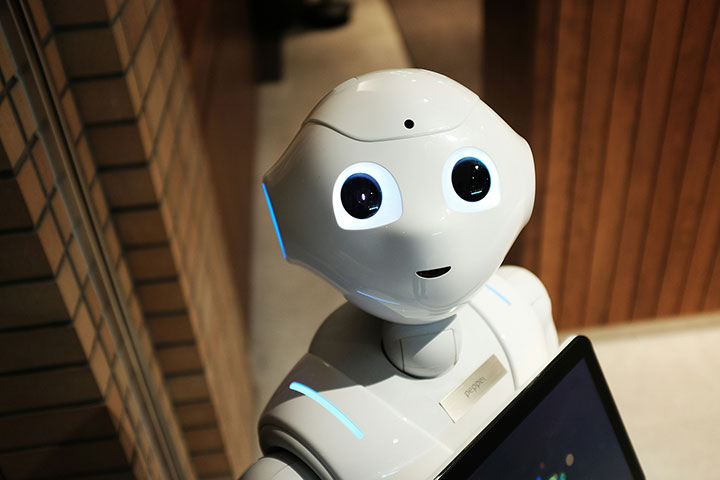 A white humanoid robot, representing the evolution of technology from bulky to sleek, modern, and interconnected devices.