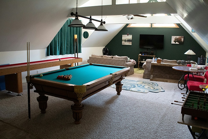 A man cave set up as a gaming room with high-quality screens, gaming equipment, comfy chairs, and cool lighting for a fun entertainment space.
