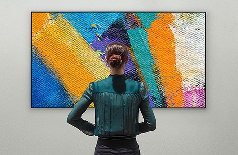 A woman enjoying an abstract artwork on a Gallery Design TV