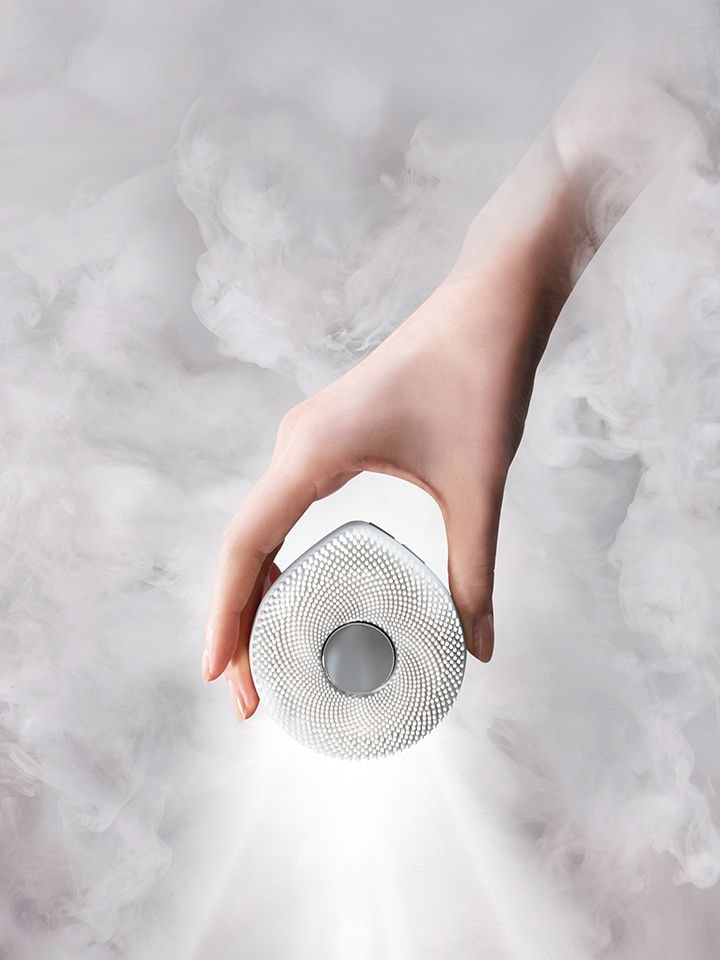 A woman is holding a WashPop close to her face.