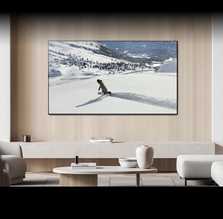 In the living room, there is a TV on the wall displaying a video of a person skiing. A message bubble saying "Send screen to bedroom TV" appears at the bottom of the screen, causing the TV to turn off and the video to continue playing on the bedroom TV. Another message bubble saying "Send screen to living room TV" appears, causing the video to switch back to the living room TV and the bedroom TV to turn off.