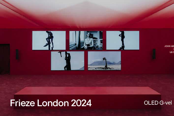 Egy vörös szobában több LG OLED G TV, melyeken műalkotások kerülnek bemutatásra