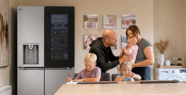Egy háromgyermekes család egy konyhában gondoskodik a gyermekekről. A háttérben hűtőszekrény, mosogatógép láthatók.