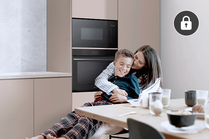 Anya és gyermeke a konyhában LG beépíthető mikrohullámú sütő előtt.