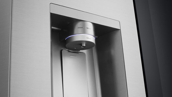 Közeli kép az LG négyajtós hűtőszekrény vízadagolójáról, mely Intelligens vízadagolás funkcióval rendelkezik. 