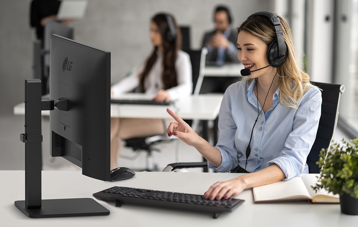 Egy hölgy a call centerben fejhallgatón keresztül beszélget az ügyféllel.