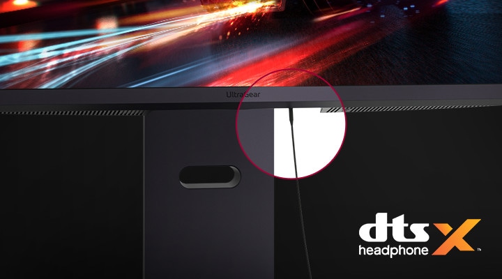 Közelkép a monitorállványról hozzácsatlakoztatott fejhallgató kábellel és a DTS Headphone X logóval.