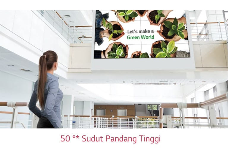 Seorang wanita melihat ke layar yang dipasang di lantai atas.