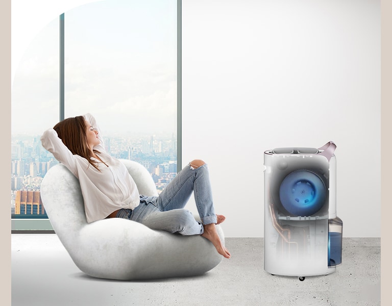 Seorang wanita beristirahat di ruangan yang nyaman di mana dehumidifier sedang berfungsi, dan di dalam dehumidifier, terlihat bahwa kipas UVnano sedang berfungsi.
