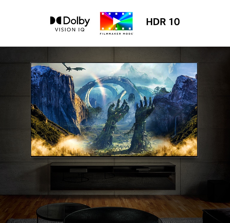 TV berlayar besar dipasang di dinding dalam ruangan yang gelap. Layarnya menayangkan adegan fantasi dengan naga yang menyemburkan api ke tanah.