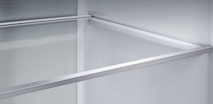 Tampilan diagonal rak dengan panel logam di bagian dalam lemari es.