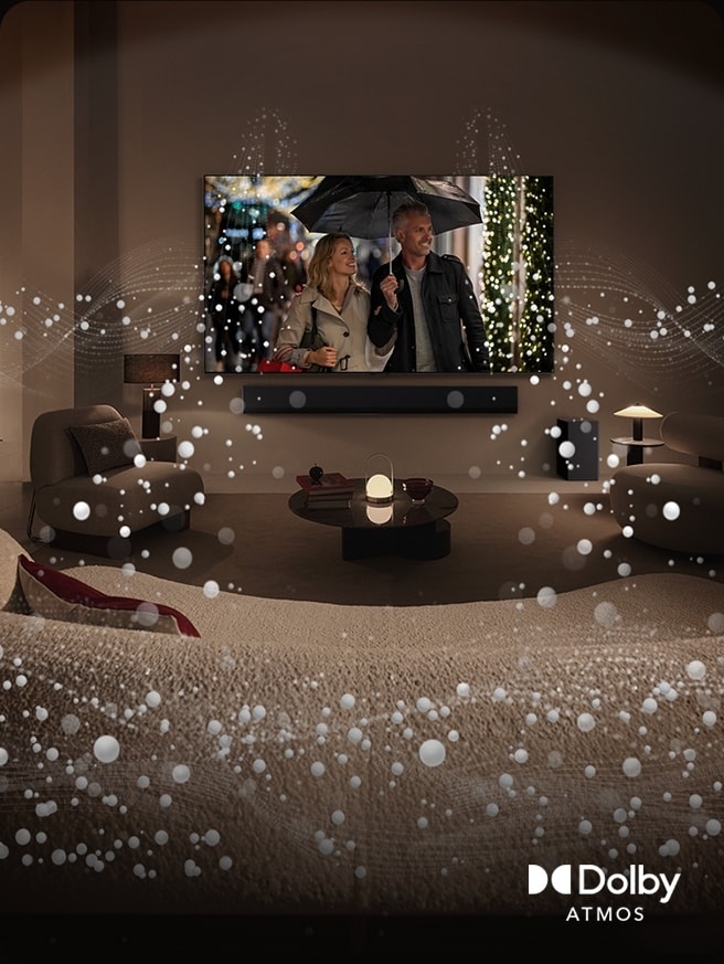 Ruang tamu yang nyaman dengan penerangan redup LG OLED TV menampilkan sepasang kekasih menggunakan payung, dan grafis lingkaran cerah mengelilingi ruangan.​ Logo Dolby Atmos di pojok kiri bawah.