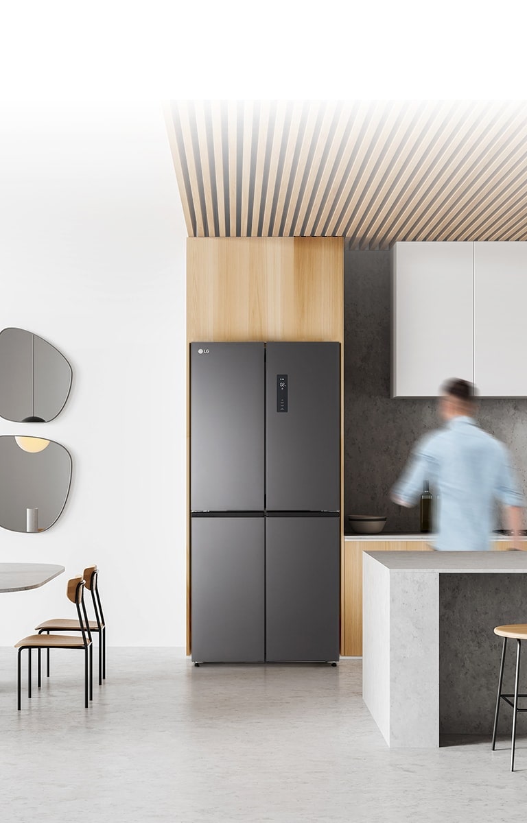 Seorang pria sedang berjalan ke arah kulkas