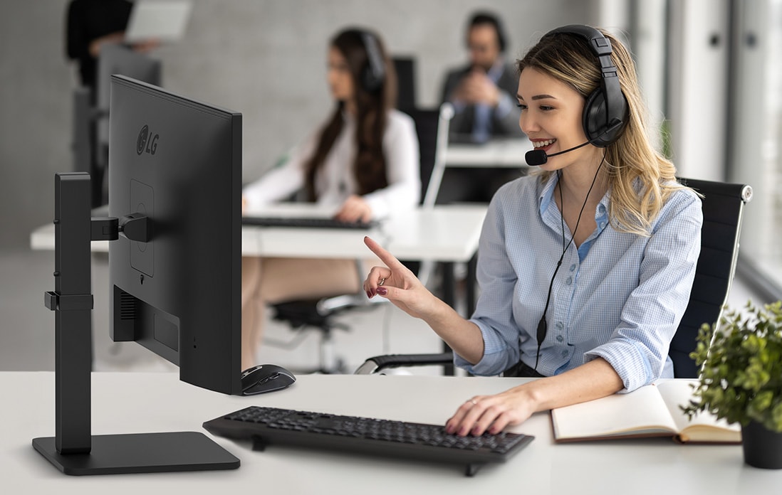 Seorang wanita menggunakan headset sedang berbicara dengan pelanggan di call center.