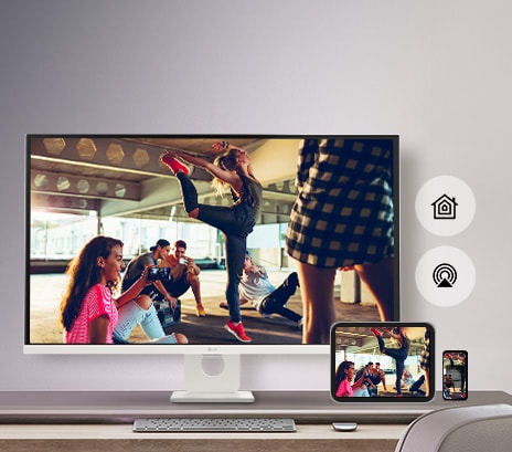 Di atas meja, ada monitor yang menampilkan adegan dari film, dan adegan yang sama ditampilkan di tablet dan perangkat seluler yang diletakkan di kanan bawah.