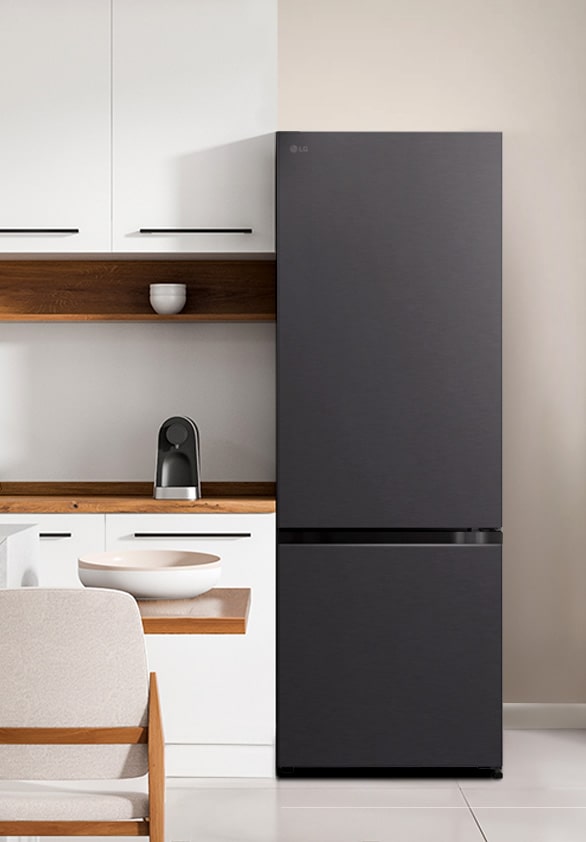 Tampilan depan kulkas LG Bottom Freezer dengan dispenser air di ruangan dapur putih modern.