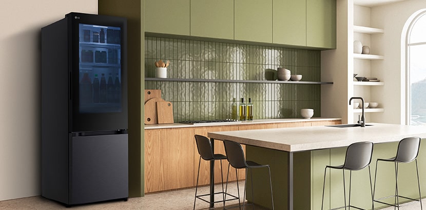 Tampilan samping kulkas LG Bottom Freezer dilengkapi dispenser air di dapur dengan kabinet hijau dan pulau yang stylish.
