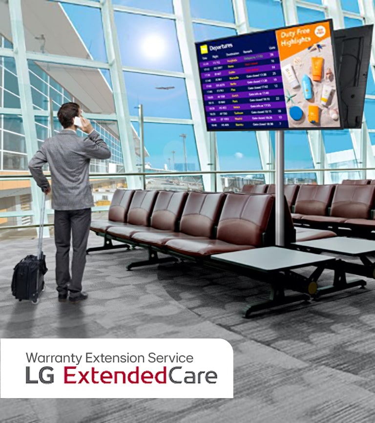 A traveler stands in an airport lounge, checking his phone while looking at a digital departure board displaying flight schedules. The scene highlights the modern, efficient use of signage for real-time updates.