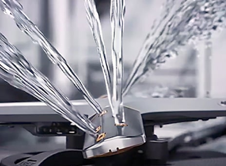 Intense water streams from dishwasher blades in close-up.