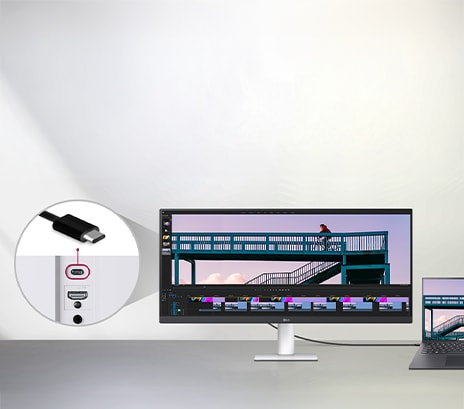 A USB Type-C cable connected between a laptop and an ultra-wide LG monitor displaying a video editing interface, with a close-up showing the USB-C port on the monitor.