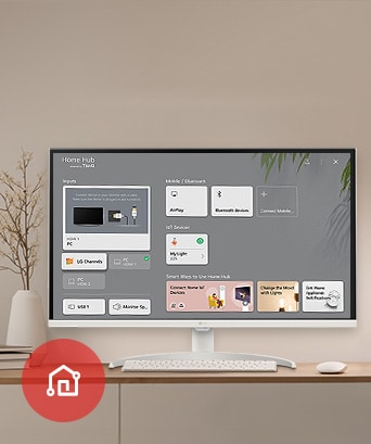 On the table, the monitor displays the Home dashboard screen, with the LG ThinQ App icon visible in the bottom left corner.