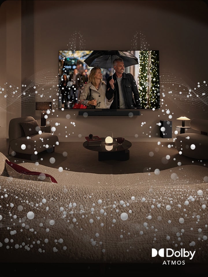 An image of a cozy, dimly lit living space. A scene is being shown on TV where a couple is using an umbrella, and bright circle graphics surround the room. Dolby atoms logo in the bottom left corner.