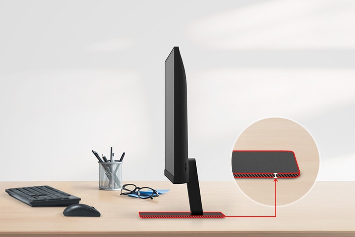 A QHD monitor with a super slim stand is on the desk, with a pencil holder, glasses, a keyboard, and a mouse next to it.