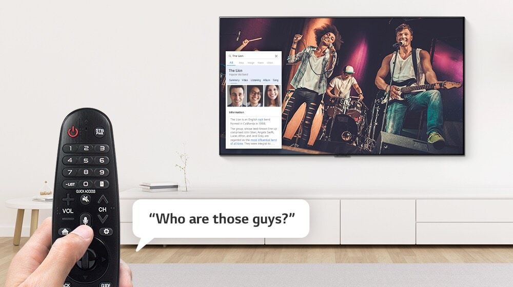 Closeup of hand controlling TV with a remote control to ask what a woman on TV is wearing.