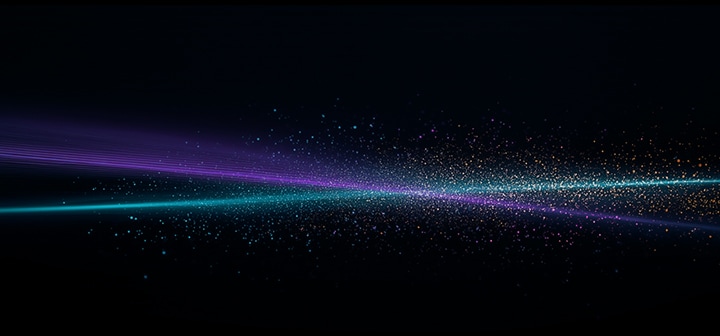 A stream of vibrant multicolored light particles flows across a dark background, forming a radiant, dynamic spectrum.
