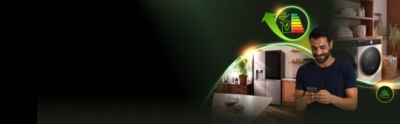 Un uomo osserva gli elettrodomestici LG a basso consumo energetico dal suo smartphone in una casa moderna, con un frigorifero, una lavatrice e un'icona di efficienza energetica.