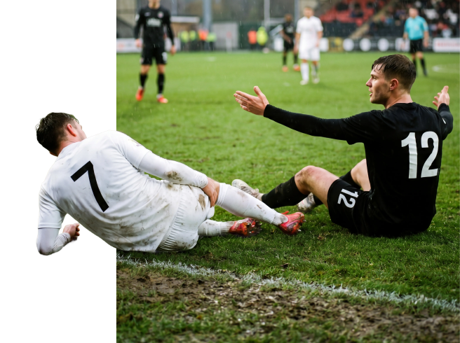 Due calciatori scivolano su un campo fangoso durante una partita, uno in uniforme bianca e l'altro in uniforme nera con il numero 12, entrambi raggiungono il pallone.