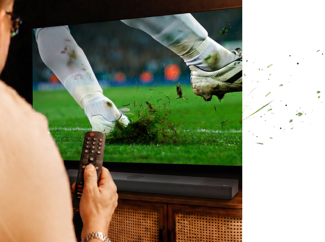 Mano che tiene un telecomando mentre si guarda una partita di calcio in TV