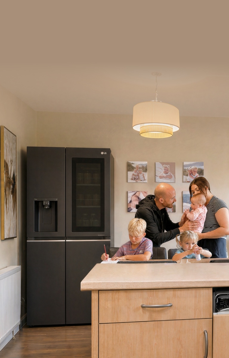 Una famiglia con tre bambini che trascorrono del tempo insieme in una cucina calda e moderna.