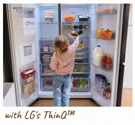 Un bambino allunga la mano dentro un frigorifero aperto, illuminato. [con LG ThinQ™]
