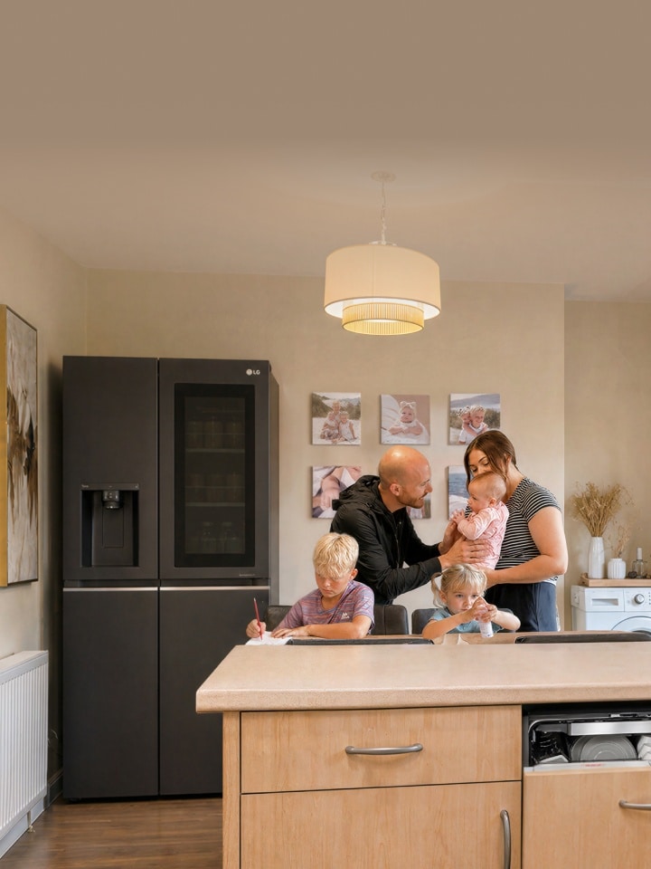 Una famiglia con tre bambini che trascorrono del tempo insieme in una cucina calda e moderna.
