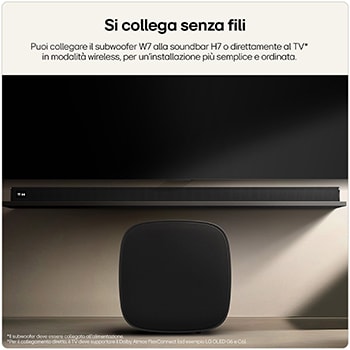 Soundbar nera installata sotto una TV con subwoofer wireless in primo piano.