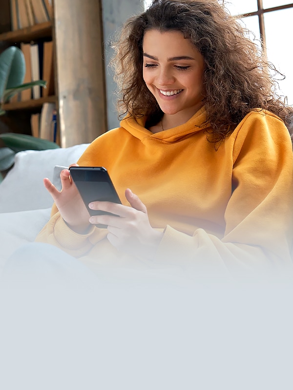 LG lavanderia stato verificato via app da una donna che sorride sul divano illustra il supporto Smart Diagnosis.