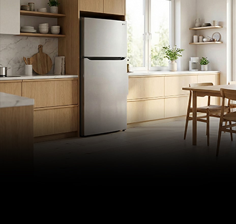 Un interno di cucina moderna con un frigorifero da incasso integrato armoniosamente nei mobili bianchi, con una zona pranzo visibile sullo sfondo.