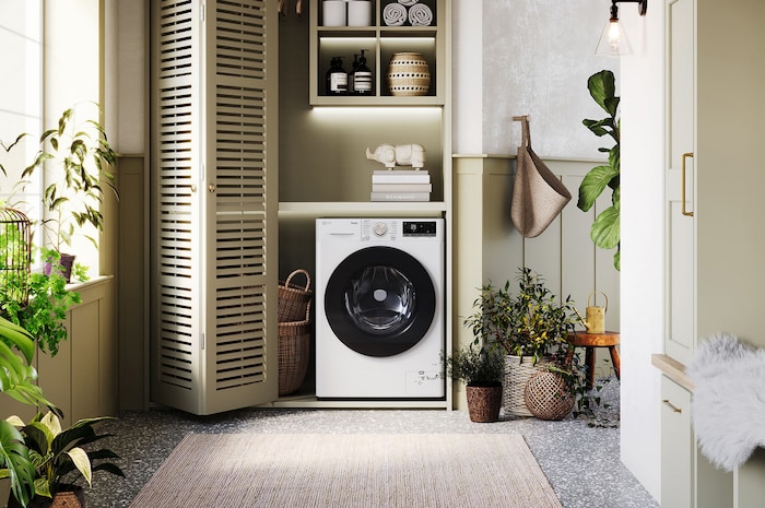 La lavatrice LG F4R7011TSWG da 11kg bianca dal design elegante, installata ordinatamente sotto il bancone di una lavanderia moderna.